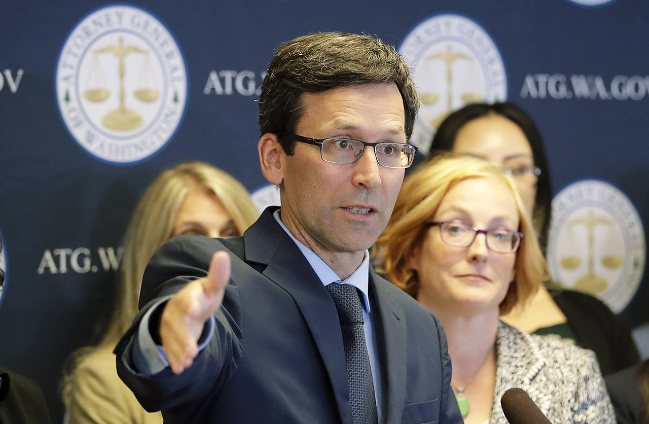 Washington Attorney General Bob Ferguson (center) talks to reporters Aug. 26 during a news conference in Seattle. (AP Photo/Ted S. Warren)