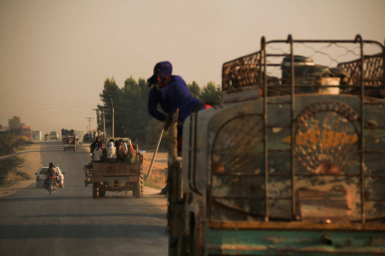 Syrians flee shelling by Turkish forces in Ras al Ayn, northeast Syria, on Wednesday. (AP Photo/Baderkhan Ahmad)