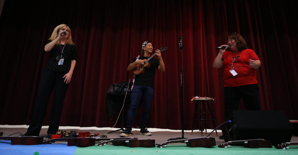 Music teachers Bobbie Ann George (right) and Joanna Bivens sing “Bohemian Rhapsody” with Jake Shimabukuro. (Andy Bronson / The Herald)
