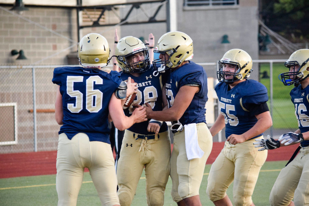 Sophomore Joey Hudson (middle) celebrates with his teammates after catching a 2-point conversion for Everett against Meadowdale on Friday, Oct. 11 at Everett Memorial Stadium. (Katie Webber / The Herald)

