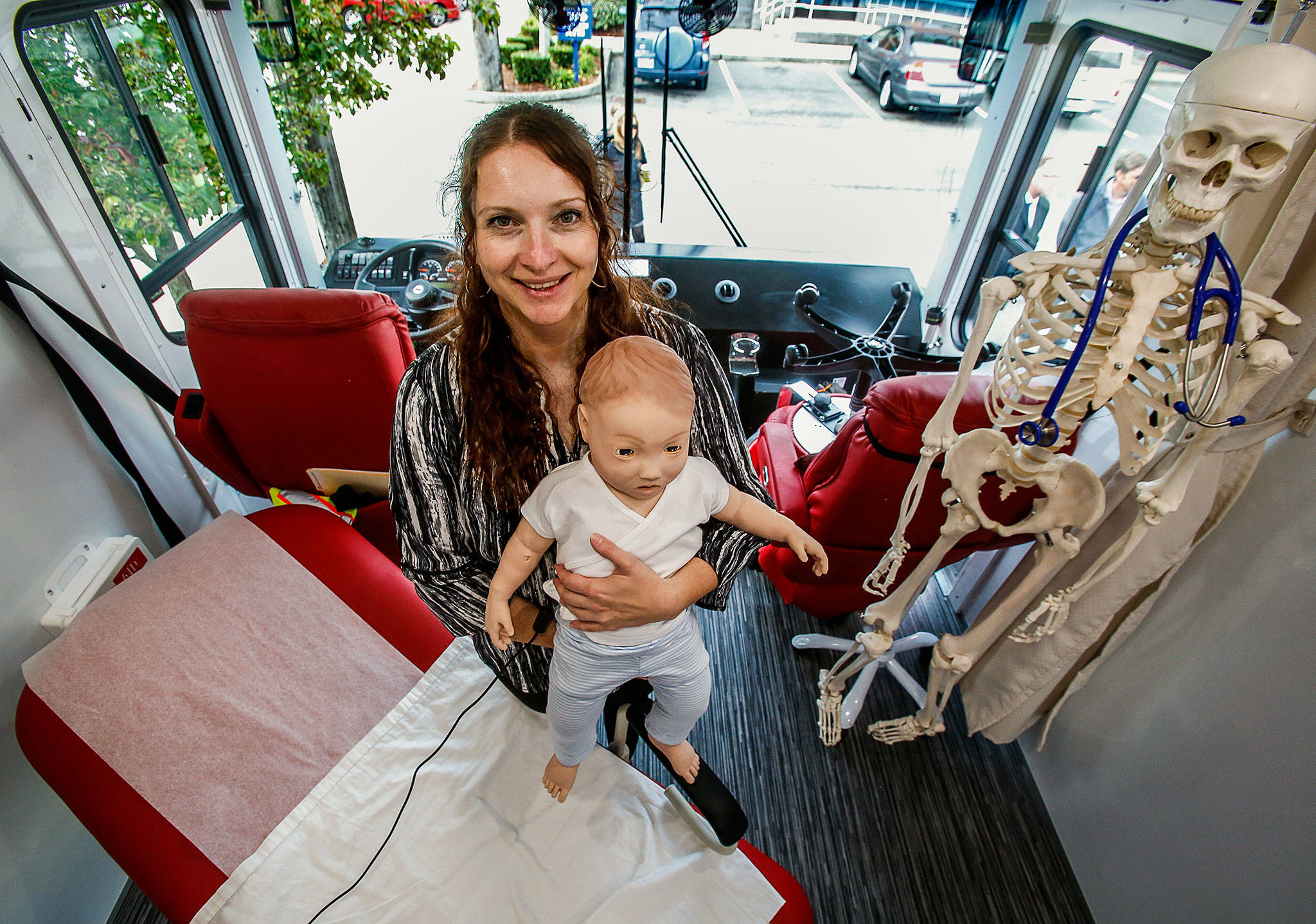 Simulation education specialist Carrie Brood, of WSU’s medical school, holds a high-fidelity mannequin used for simulated patient care in the Range Health mobile unit displayed in Everett on Thursday. (Dan Bates / The Herald)