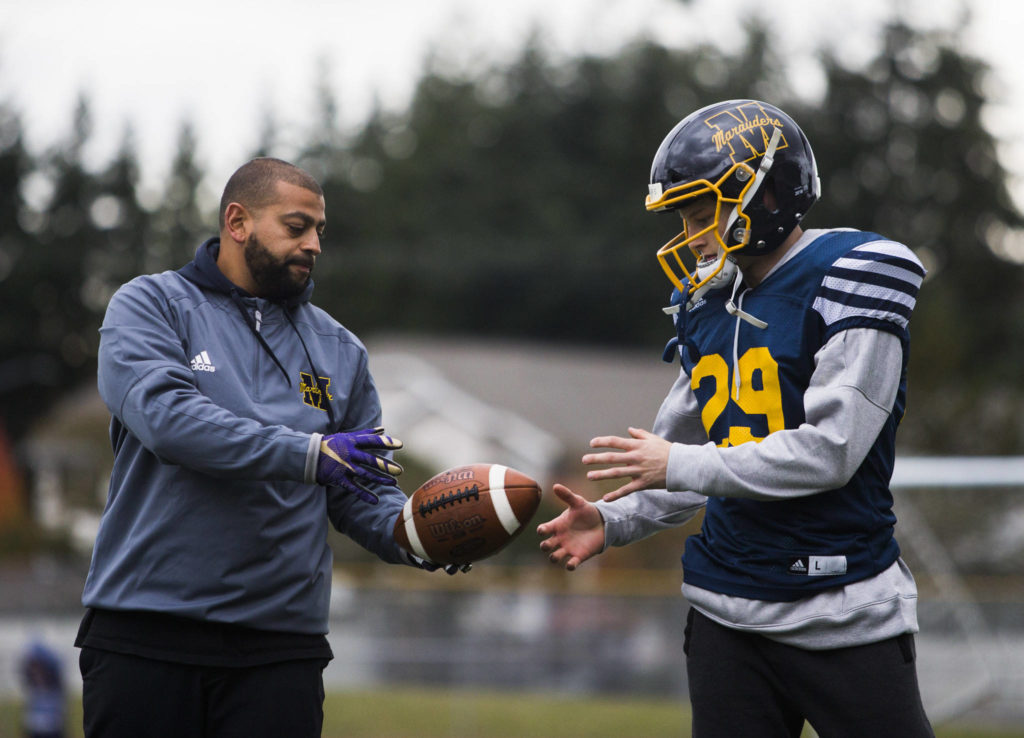 Mariner High School’s Jackson Cole (right) talks with Marauders’ quarterbacks coach Tony Young (left) during the team’s Oct. 17 practice at Goddard Stadium in Everett. (Olivia Vanni / The Herald)
