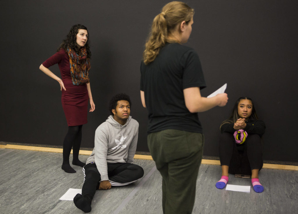 From left, Deborah Hathaway, Sofonias Shiferawand Michah Dizon listen to Alex Andreeva in a class that combines creative writing and acting. (Olivia Vanni / The Herald)
