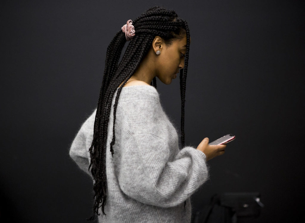 Afomeya Mesfin reads her essay off her phone to her group during class at UW Bothell. (Olivia Vanni / The Herald)
