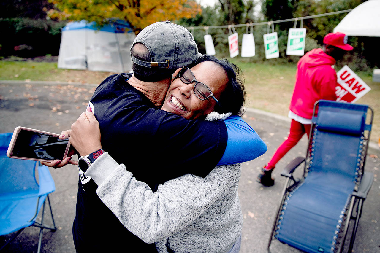 Picketing United Auto Workers Richard Rivera (left) and Robin Pinkney react to news of a tentative contract agreement with General Motors in Langhorne, Pennsylvania, on Wednesday. (AP Photo/Matt Rourke)