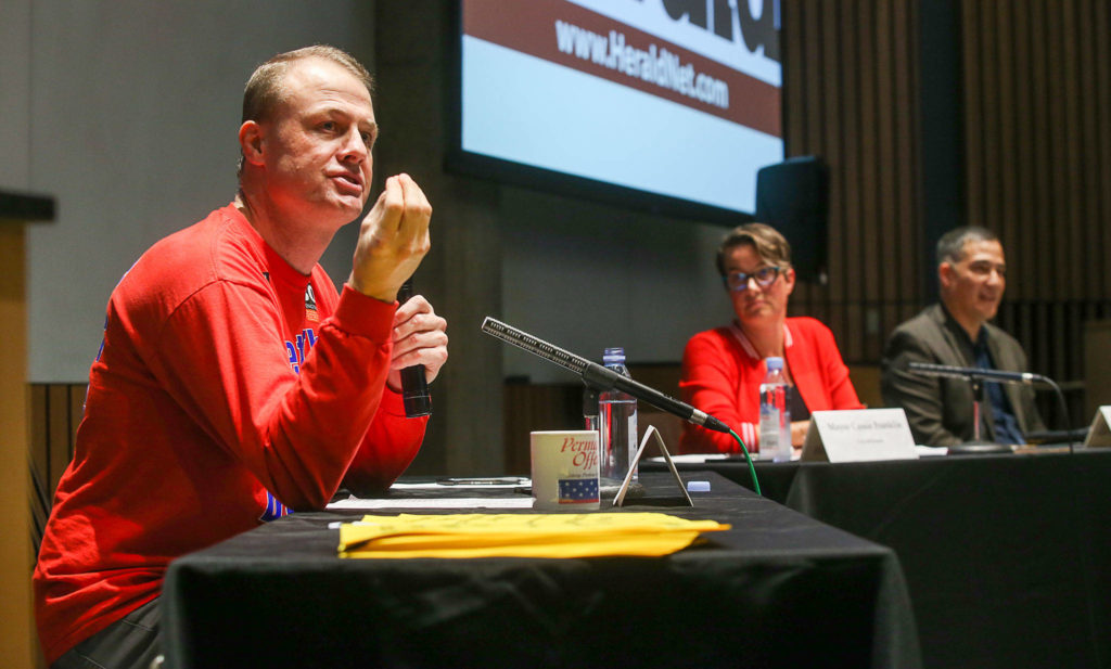 Everett Mayor Cassie Franklin (center) and Steve Hobbs (right), the Democratic chairman of the state Senate Transportation Committee, listen as initiative sponsor Tim Eyman makes the case in favor of I-976 at a Herald forum Thursday night at Washington State University’s North Puget Sound campus in Everett. (Andy Bronson / The Herald)
