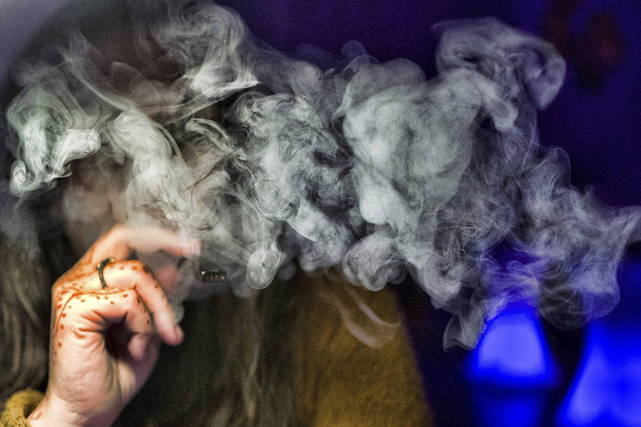 A woman takes a puff from a cannabis vape pen Dec. 22, 2018, in Los Angeles. California health officials were urging consumers to stop vaping of any kind until investigators determined why hundreds of people nationwide have been sickened after using the devices. The mysterious lung illness has also spread to Washington state. (AP Photo/Richard Vogel, File)