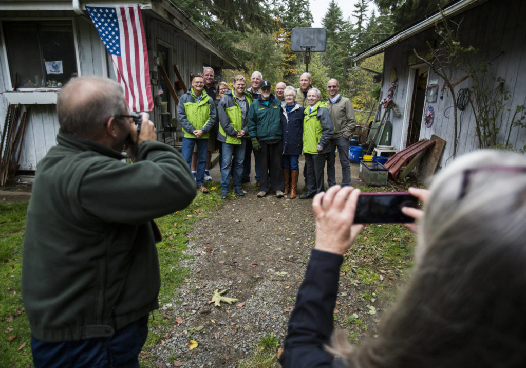 A group of friends, family and Snohomish County officials gather for a group photo at Jim Corcoran’s home near Mill Creek on Friday. (Olivia Vanni / The Herald)
