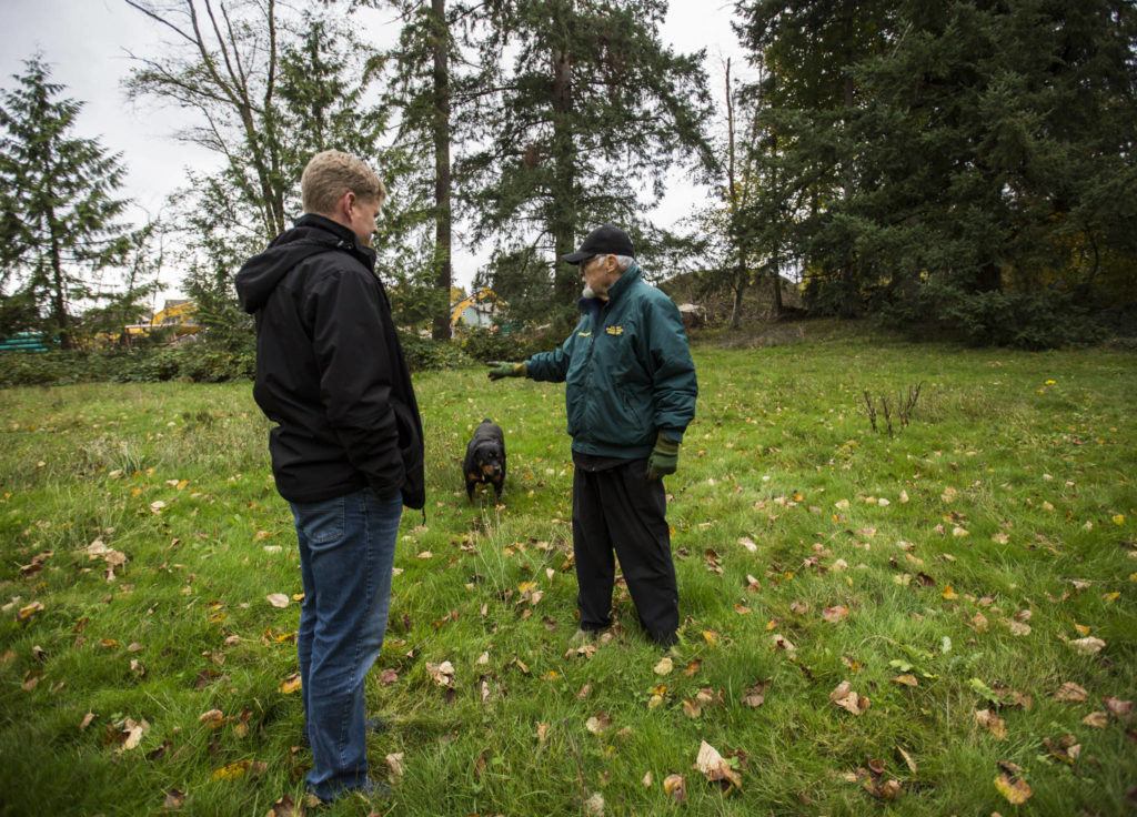 Jim Corcoran (right) talks to Ken Klein from the Snohomish County Executive’s Office about a small baseball field on his land near Mill Creek. (Olivia Vanni / The Herald)

