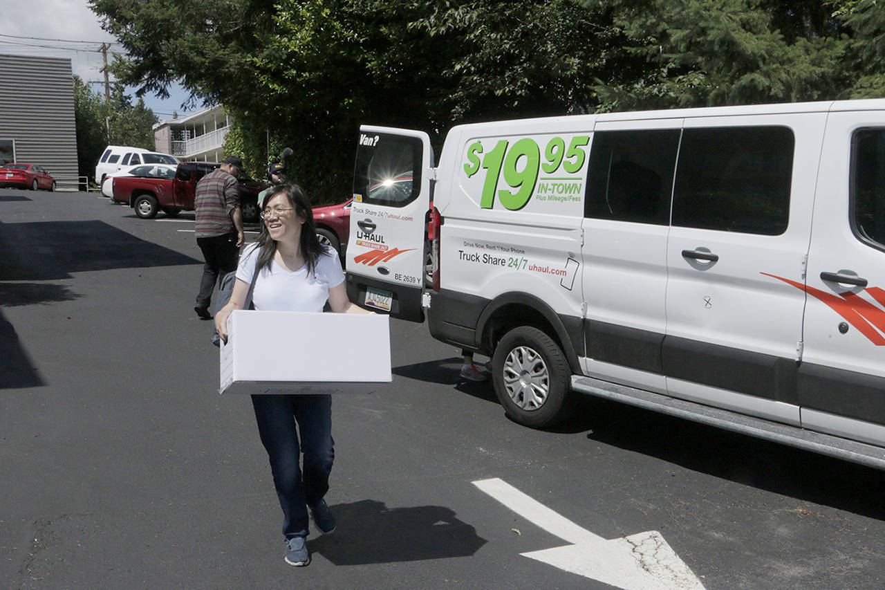 Linda Yang, with the ‘Let People Vote’ campaign, carries a box of signed petitions for Referendum 88, on July 24 in Olympia. Proponents of the referendum are opposed to an affirmative action measure approved by the Legislature earlier this year that permits state agencies to establish diversity goals and timelines, and consider membership in a minority group as a contributing factor for an applicant. (AP Photo/Rachel La Corte file)