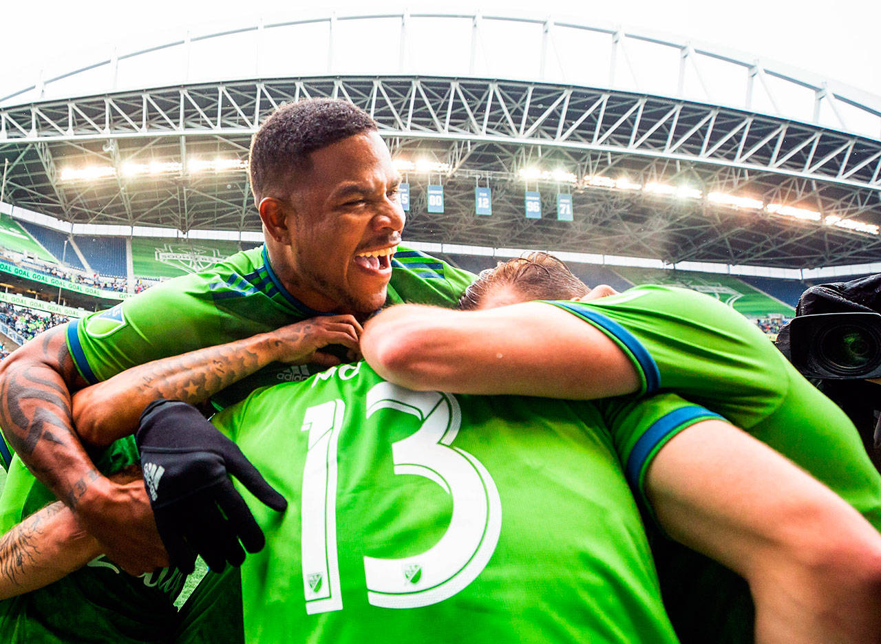 The Sounders’ Roman Torres (29) celebrates a goal by Jordan Morris (13) during the first half of an MLS playoff match against FC Dallas on Oct. 19, 2019, in Seattle. (Andy Bao/The Seattle Times via AP)