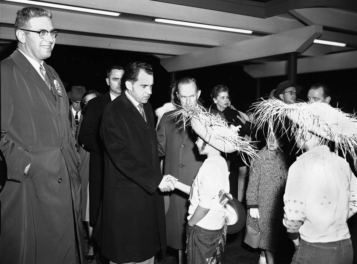 Vice President Richard Nixon shakes the hand of George Forbes Jr., son of Paine Field airport manager and Mrs. George Forbes, following the vice president’s arrival on a chartered plane to speak at a Everett campaign rally on Oct. 31, 1958. (Jim Leo / Herald file / Everett Public Library)