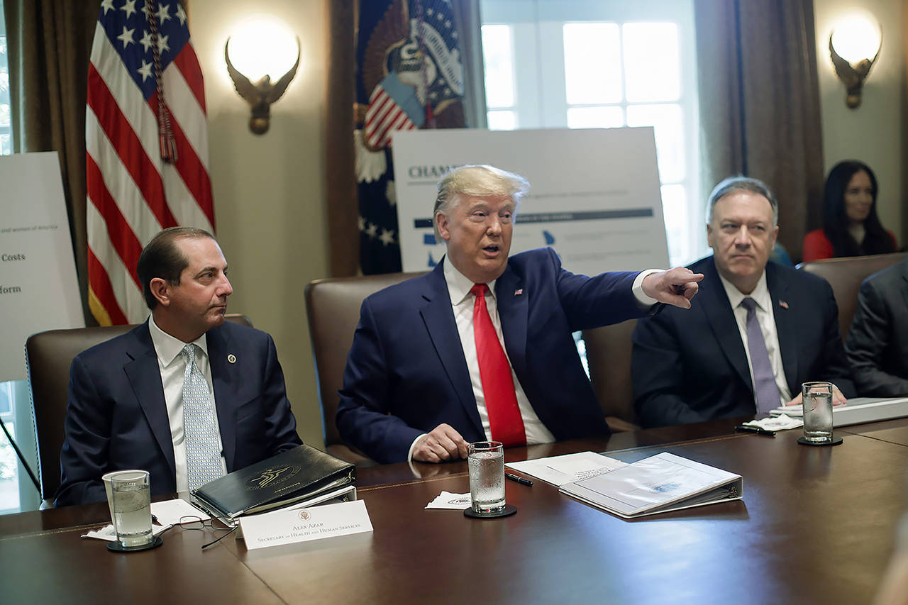 President Donald Trump points to members of his Cabinet while speaking during a Cabinet meeting in the Cabinet Room of the White House on Monday, as Health and Human Services Secretary Alex Azar (left) and Secretary of State Mike Pompeo (right) listen. (AP Photo/Pablo Martinez Monsivais)