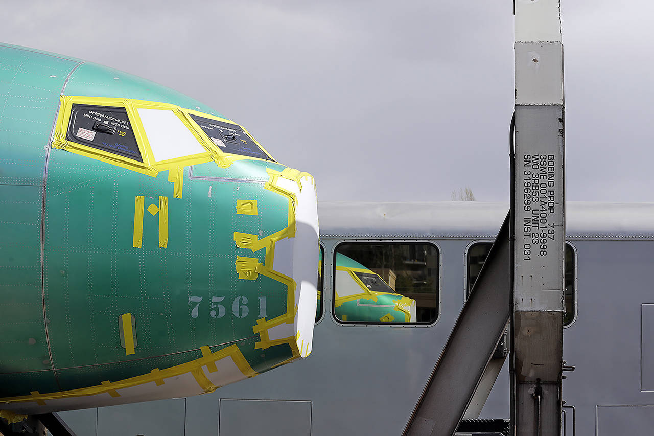 This April 9 photo shows the front of a Boeing 737 fuselage, eventually bound for Boeing’s production facility in Renton, sits on a flatcar rail car and is reflected in a nearby passenger train car at a rail yard in Seattle. (AP Photo/Elaine Thompson, File)