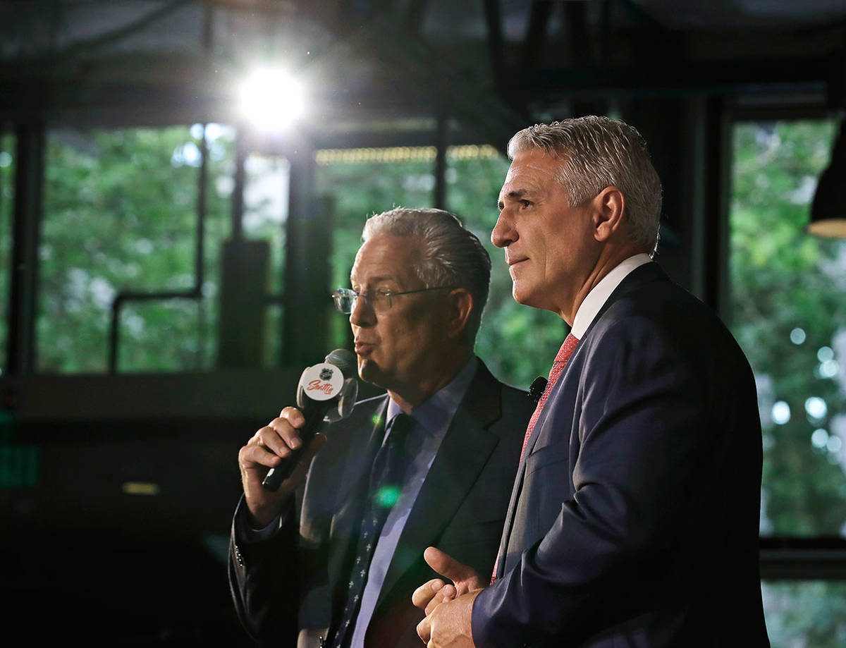Ron Francis (right) and Seattle Hockey Partners CEO Tod Leiweke take questions from reporters during a news conference on July 18, 2019, in Seattle. (AP Photo/Ted S. Warren)