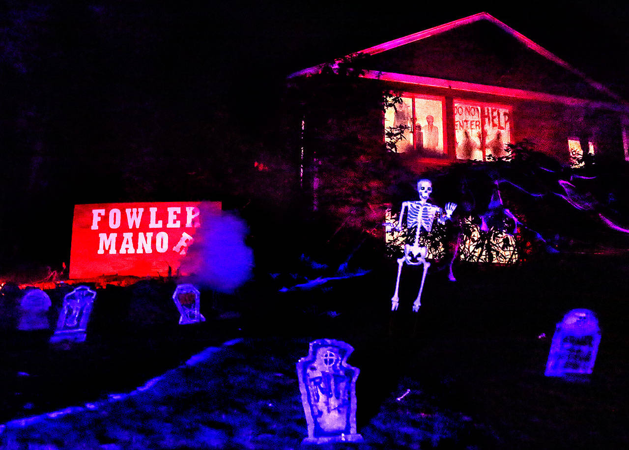 Dubbed “Fowler Manor,” Aaron and Dani Ackert’s home on Fowler Avenue in Everett features a graveyard with 30 tombstones where the dead are definitely not resting in peace. Their sons, Daxton and Kruz helped set up the spooky scene, which has colored strobe lights and fog machines. (Dan Bates / The Herald)