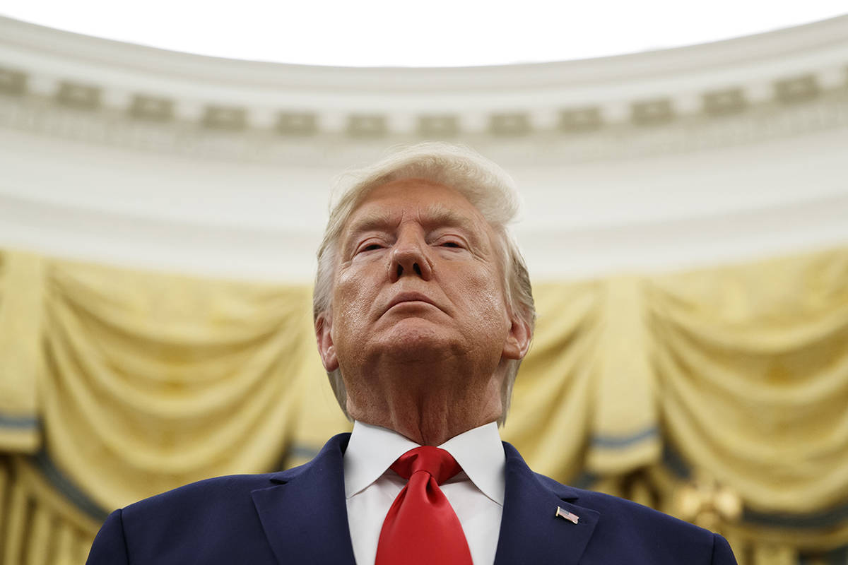 President Donald Trump stands during a Presidential Medal of Freedom ceremony for auto racing great Roger Penske in the Oval Office of the White House on Thursday in Washington. (AP Photo/Alex Brandon)