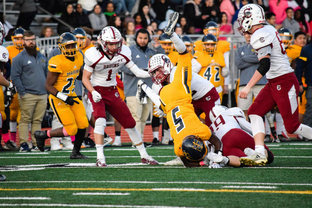 The Cascade defense tackles Mariner’s senior running back Prince Riley (5) on Friday, Oct. 25 at Goddard Stadium in Everett. (Katie Webber / The Herald)
