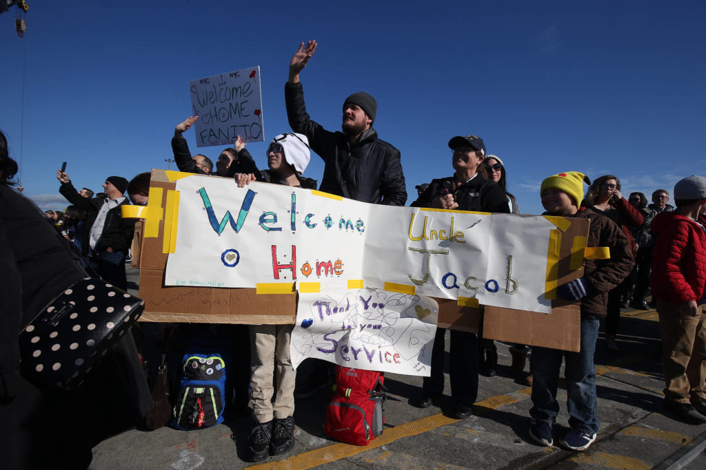 Families and friends wait to greet sailors from the USS Momsen (DDG-92) as it returns to Naval Station Everett after a deployment to the Pacific on Monday in Everett. (Andy Bronson / The Herald)

