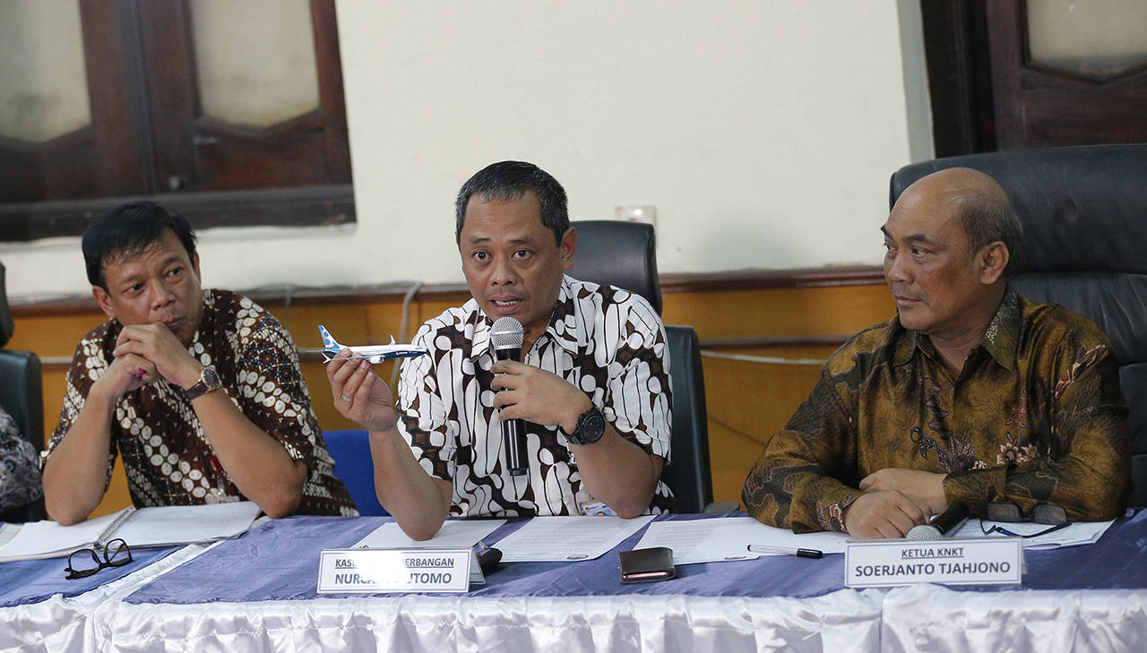 National Transportation Safety Committee investigator Nurcahyo Utomo (center) holds a model of an airplane and Chairman of the National Transportation Safety Committee Soerjanto Tjahjono (right) listens during a press conference in Jakarta, Indonesia on Friday. An Indonesian investigation found a Lion Air flight that crashed and killed 189 people a year ago was doomed by a combination of aircraft design flaws, inadequate training and maintenance problems. (AP Photo/Tatan Syuflana)