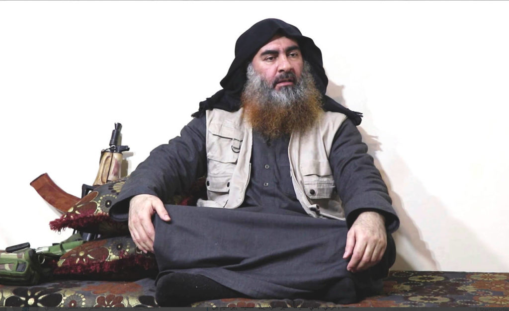 This file image made from video posted on a militant website April 29, 2019, purports to show the leader of the Islamic State group, Abu Bakr al-Baghdadi, being interviewed by his group’s Al-Furqan media outlet. The Islamic State erupted from the chaos of Syria and Iraq’s conflicts and swiftly did what no Islamic militant group had done before, conquering a giant stretch of territory and declaring itself a “caliphate.” U.S. officials said late Saturday, Oct. 26, 2019 that al-Baghdadi was the target of an American raid in Syria and may have died in an explosion. (Al-Furqan media via AP, File)
