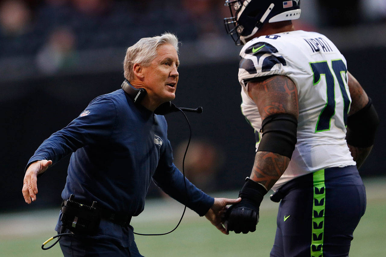 Seattle Seahawks head coach Pete Carroll interacts with offensive lineman Mike Iupati during Sunday’s game in Atlanta. (AP Photo/John Bazemore)                                Seattle Seahawks head coach Pete Carroll and his staff earned a D+ because of their team’s listless performance in the second half. (AP Photo/John Bazemore)