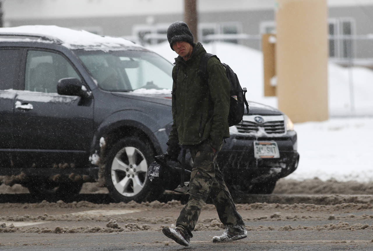 A pedestrian crosses a Denver street Monday. (AP Photo/David Zalubowski)