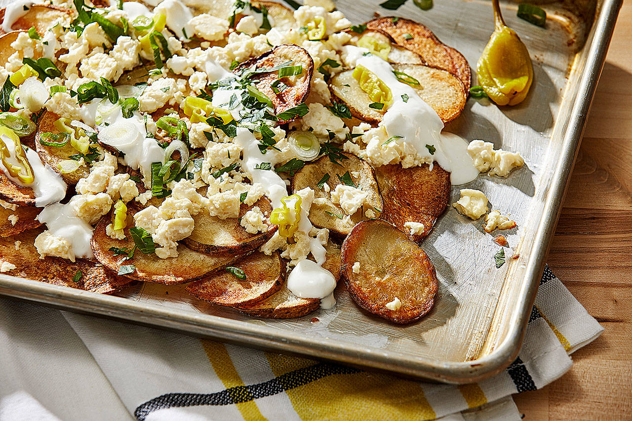 Feel free to leave Greek-ish potato nachos on the sheet pan to serve the feta-topped crisps from the pan. (Photo by Tom McCorkle for The Washington Post)