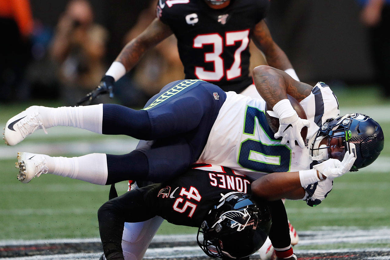 Seahawks running back Rashaad Penny (20) is hit by Falcons linebacker Deion Jones (45) during the first half of a game Sunday in Atlanta. (AP Photo/John Bazemore)