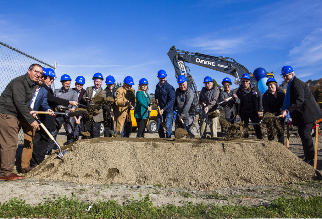 Everett officials along with contractors and construction company members break ground at the Waterfront Place Apartments along the Everett waterfront Wednesday. (Olivia Vanni / The Herald)
