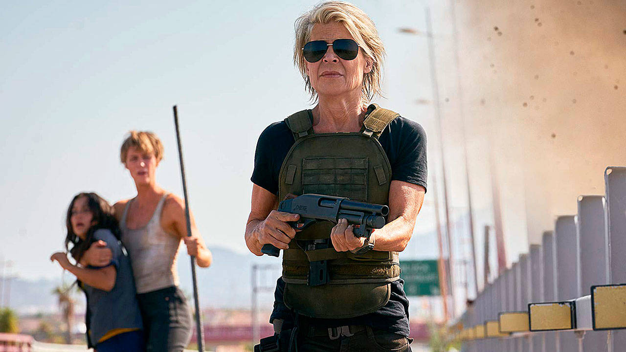 Linda Hamilton returns as Sarah Connor, older but still locked and loaded, in “Terminator: Dark Fate.” In the background are Natalia Reyes and Mackenzie Davis. (Paramount Pictures)
