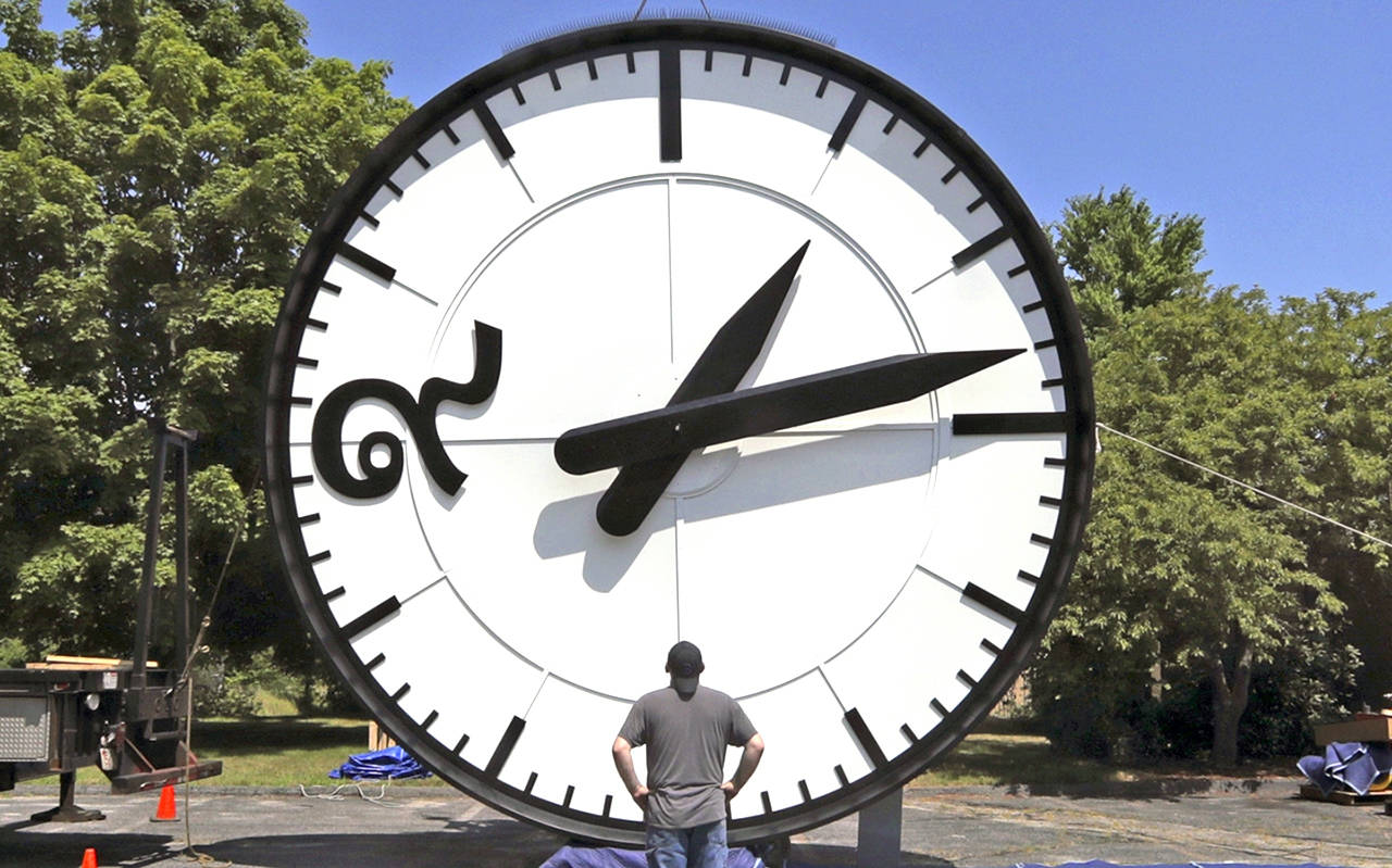 In this July 25 photo, workers at the Electric Time Company in Medfield, Massachusetts, test a 20-foot-high clock, built for the a new train station in Bangkok, Thailand. Daylight saving time ends at 2 a.m. local time Sunday, Nov. 3, when clocks are set back one hour. (AP Photo/Charles Krupa)