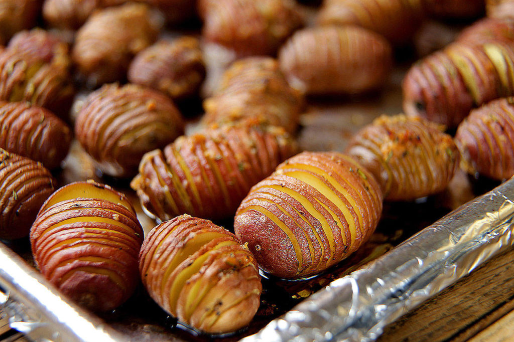 Gently fan the Hasselback potatoes out on a foil-lined rimmed baking sheet. (Kirk McKoy / Los Angeles Times)
