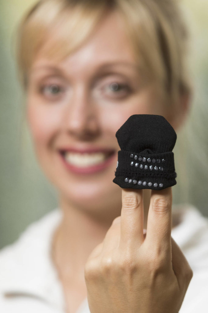 Jessica Miller, co-owner of Squid Socks, shows off the silicone dots that keep them from slipping from the feet of toddlers. (Andy Bronson / The Herald)
