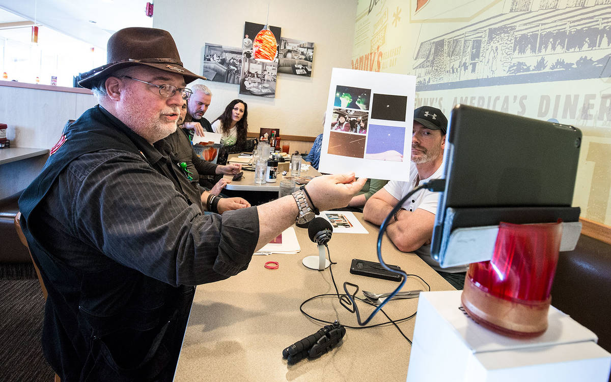 Michael W. Hall, who heads a group called the UFOiTeam, shows photos of an unidentified flying object to a live stream audience during a meeting in 2018. (Andy Bronson / The Herald)
