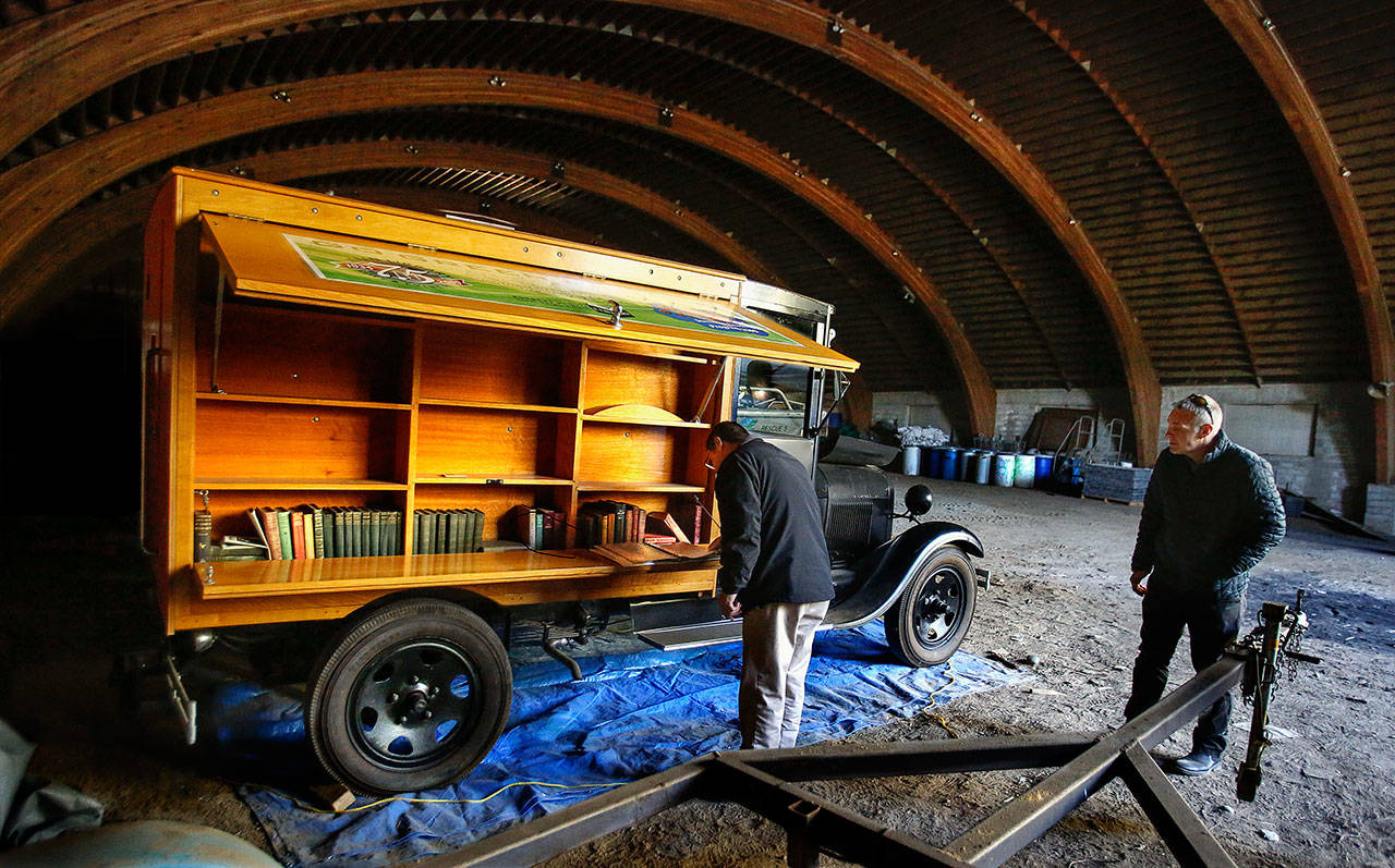 Everett’s antique bookmobile, Pegasus, is stored in a massive building just south of Thornton A. Sullivan Park at Silver Lake. Ruben Sanchez (left) and Doug Acheson, both with the city, look over the 1924-1929 customized Ford. It may eventually be on display at the Everett Museum of History. (Dan Bates / The Herald)