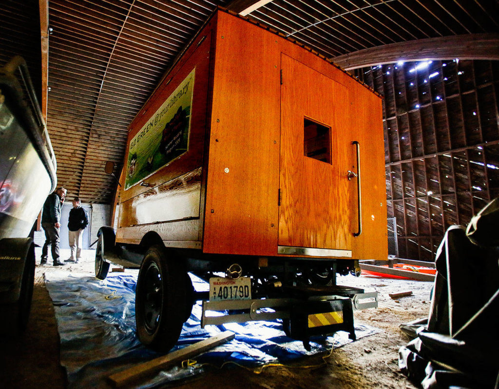 Two city of Everett employees take a look at Pegasus, a vintage bookmobile now in storage in a building near Silver Lake that they call “the dome.” (Dan Bates / The Herald)
