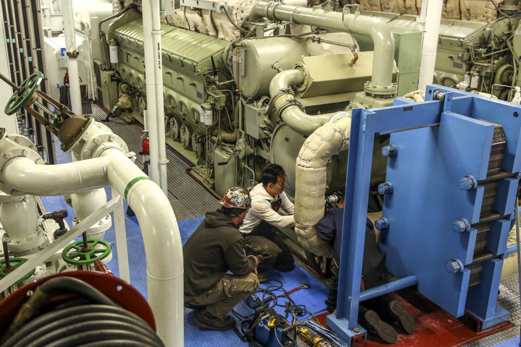 Crews work to replace and refit a water filter system aboard the Puyallup at the Eagle Harbor Maintenance Facility in Bainbridge on October 31, 2019. (Kevin Clark / The Herald)
