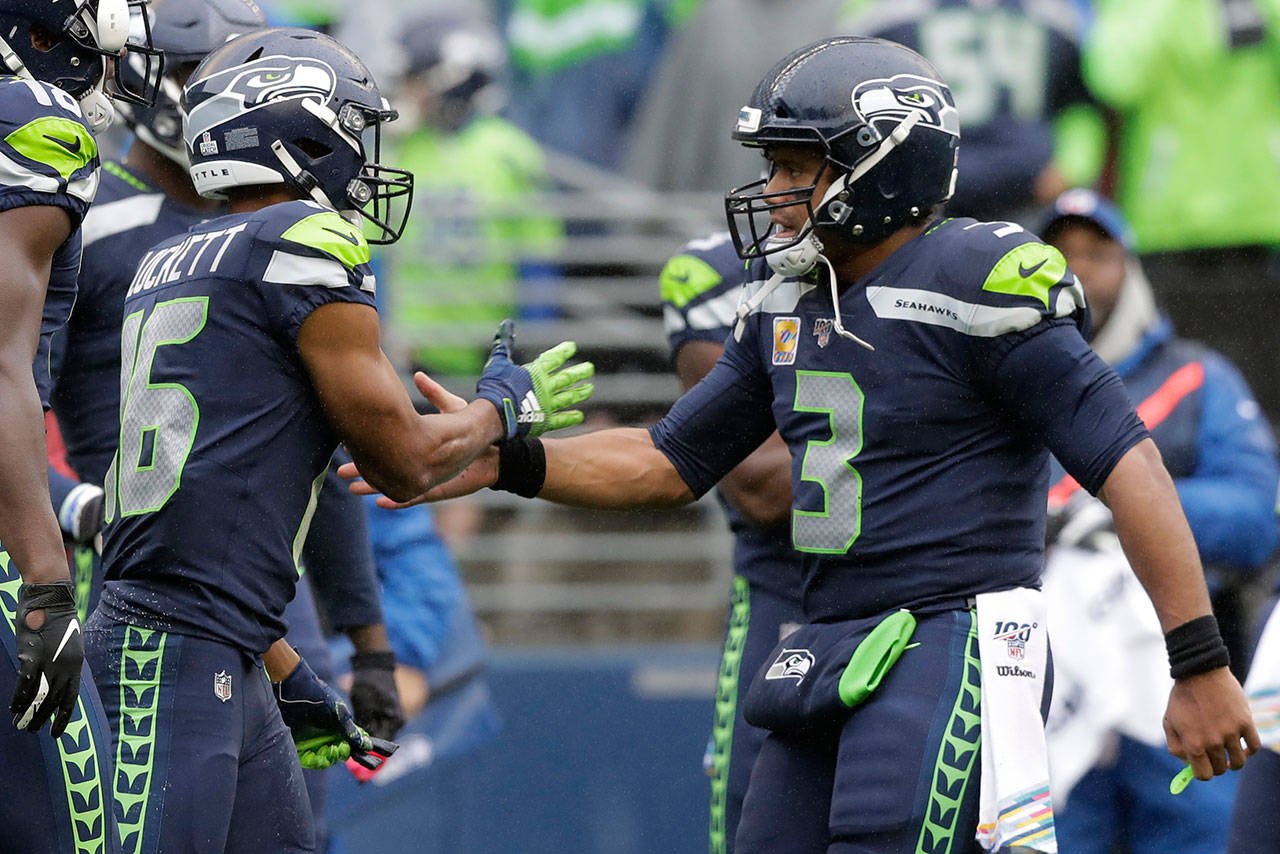 Seahawks quarterback Russell Wilson (3) greets wide receiver Tyler Lockett (16) after Lockett caught a pass from Wilson for a touchdown during the first half of a game against the Ravens on Oct. 20, 2019, in Seattle. (AP Photo/John Froschauer)