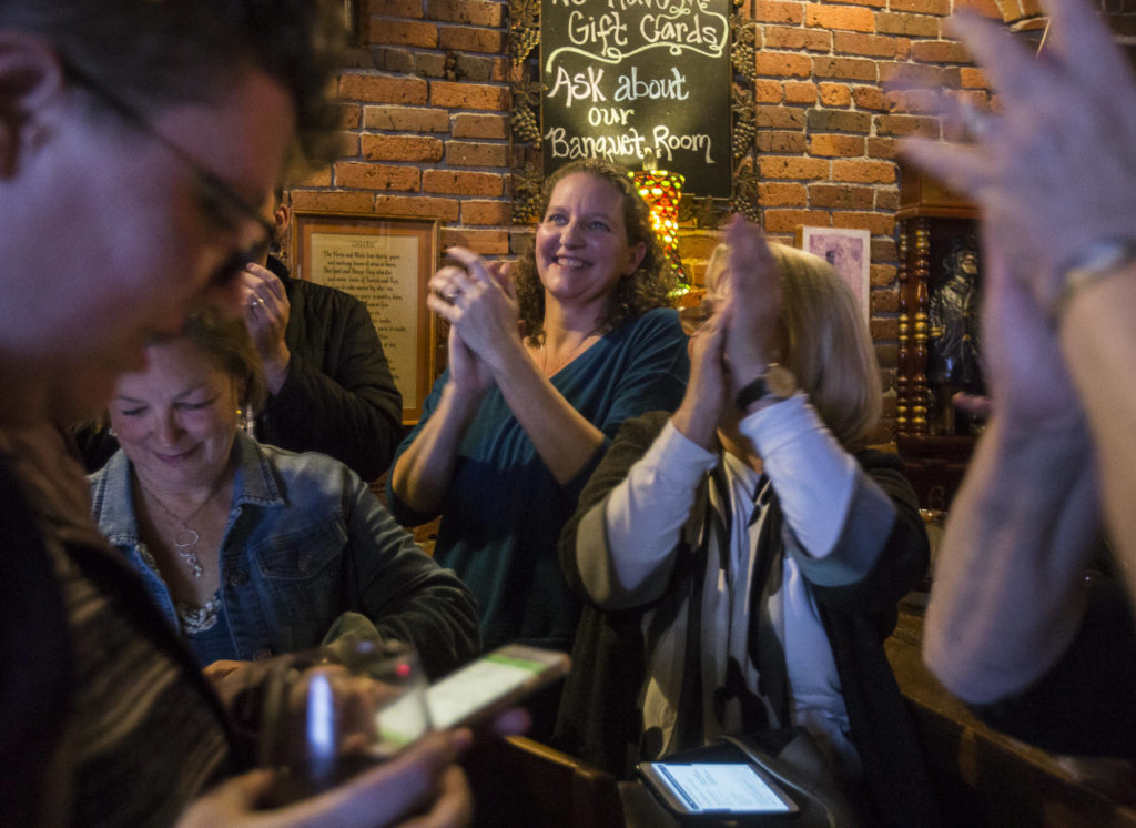 Snohomish County Council candidate Megan Dunn claps along with supporters as the first numbers come in on election night at the Vintage Cafe in Everett. (Olivia Vanni / The Herald)
