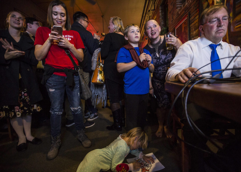 Everett City Council candidate Liz Vogeli (right) talks with her son Emmett Vogeli, 8, as the first numbers put her in the lead on election night at the Vintage Cafe in Everett. (Olivia Vanni / The Herald)
