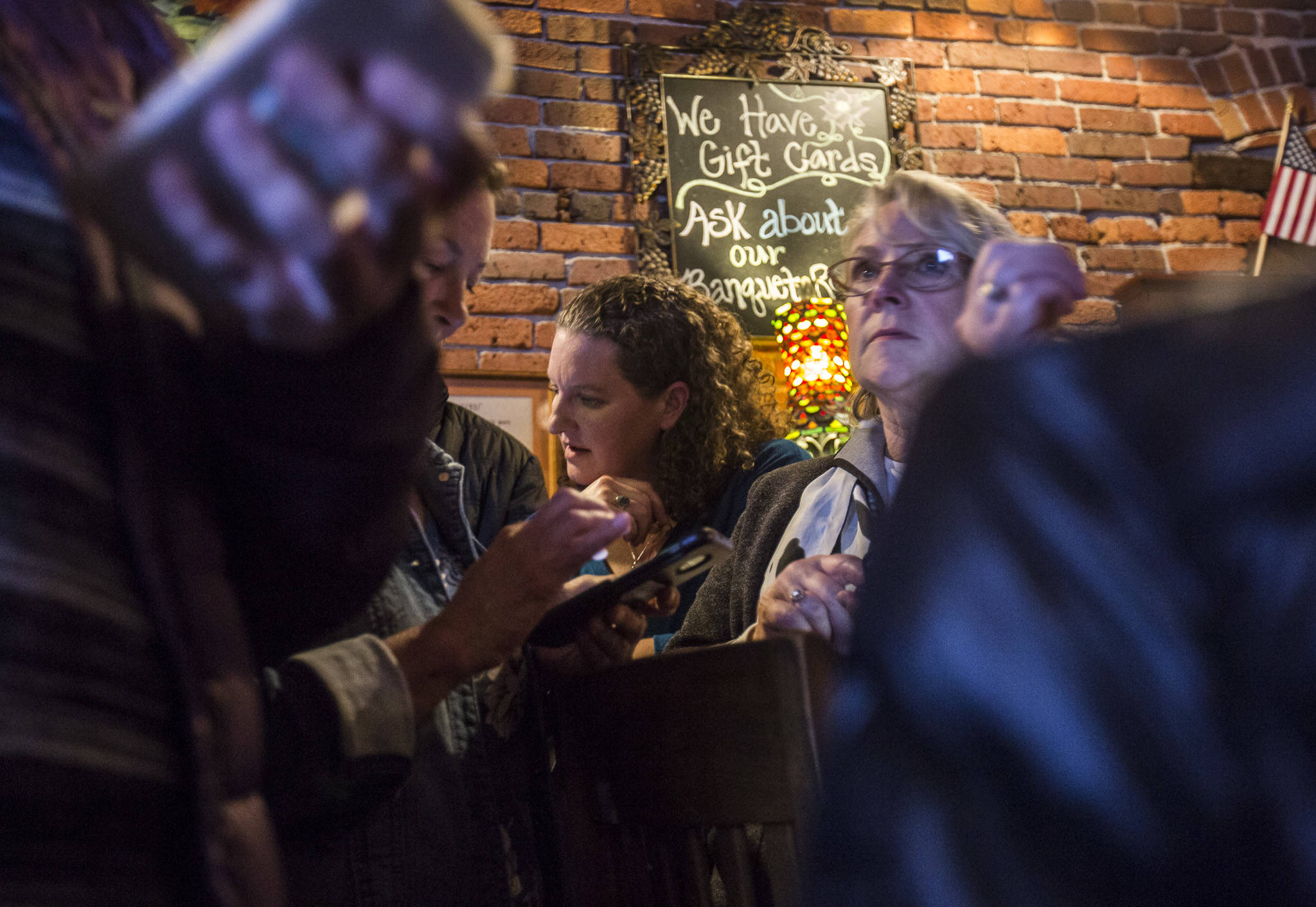 Snohomish County Council candidate Megan Dunn checks her phone as the first numbers come in on election night at the Vintage Cafe in Everett. (Olivia Vanni / The Herald)