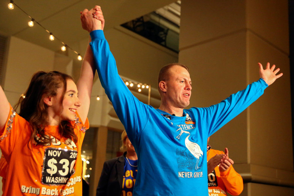 Tim Eyman declares victory with his daughter Riley Eyman (left) Tuesday evening at Hyatt Regency in Bellevue. (Kevin Clark / The Herald)
