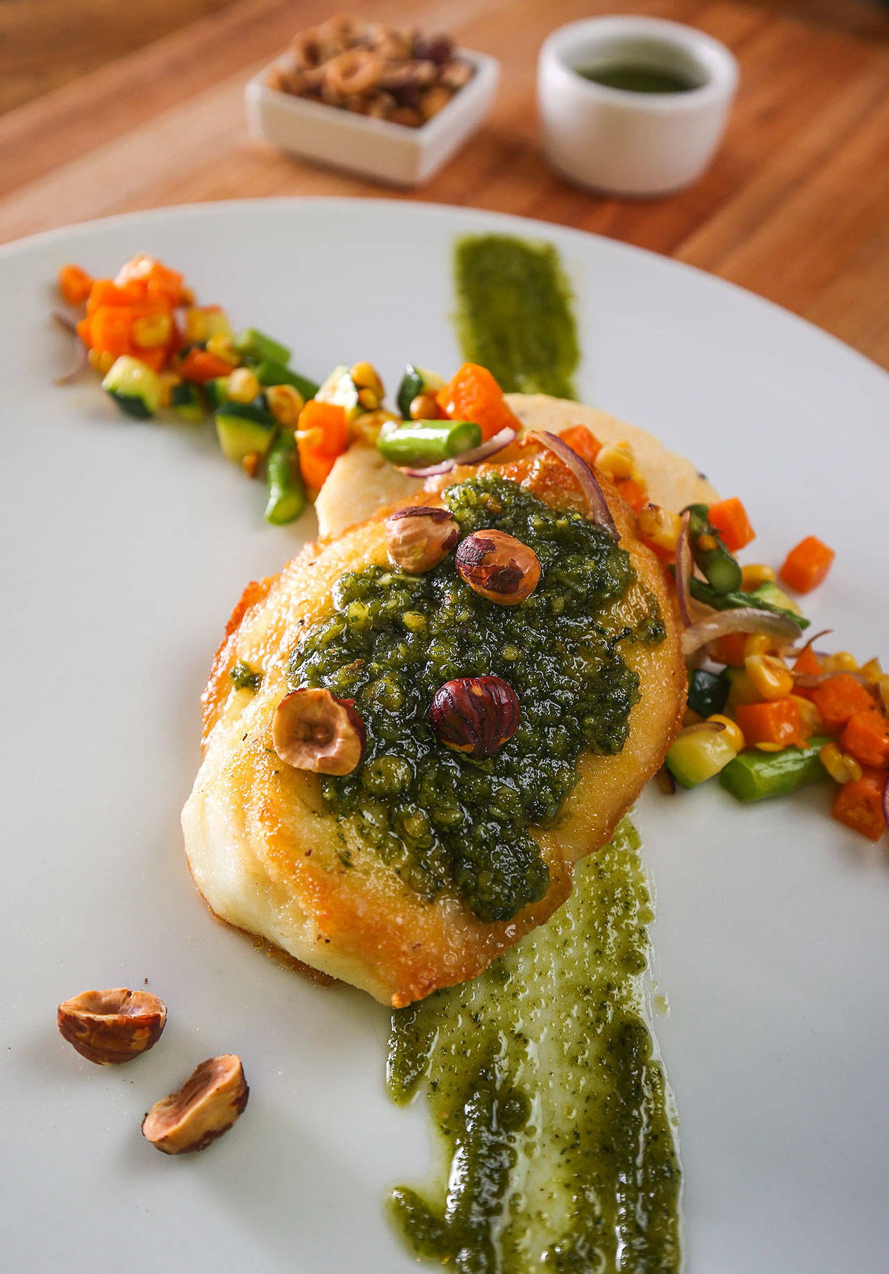 Chef David Buchanan’s sea bass is served with hazelnut pesto, havarti polenta and autumn succotash at Blackfish Wild Salmon Grill and Bar. (Andy Bronson / The Herald)