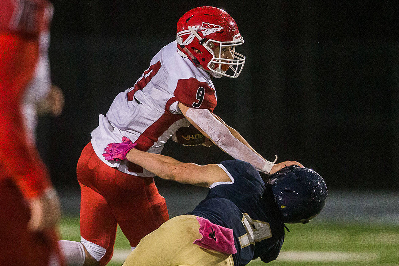 Marysville-Pilchuck’s Jordan Justice pushes Arlington’s Joseph Schmidt to the ground during the game on Oct. 25, 2019 in Arlington, Wash. (Olivia Vanni / The Herald)