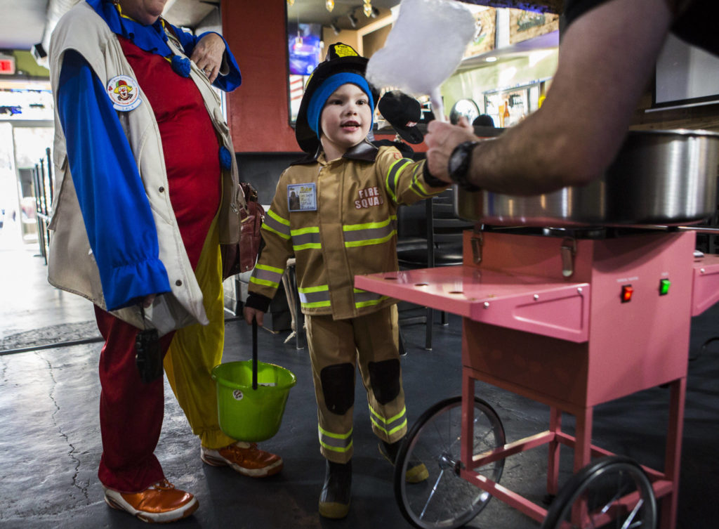 Desmond Smith, 5, gets a cotton candy from Eight Ball Cafe during Downtown Trick-or-Treating on Oct. 31, 2019 in Everett, Wash. (Olivia Vanni / The Herald)
