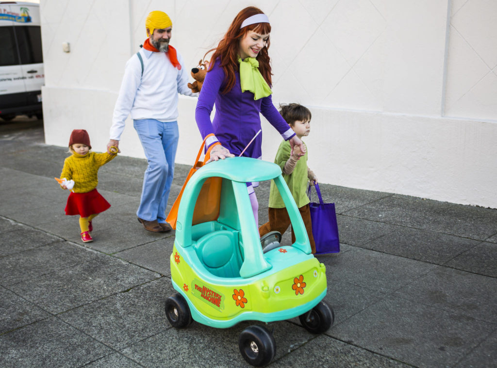 A family dressed as the charters from “Scooby Doo” walk along California Street during Downtown Trick-or-Treating on Oct. 31, 2019 in Everett, Wash. (Olivia Vanni / The Herald)
