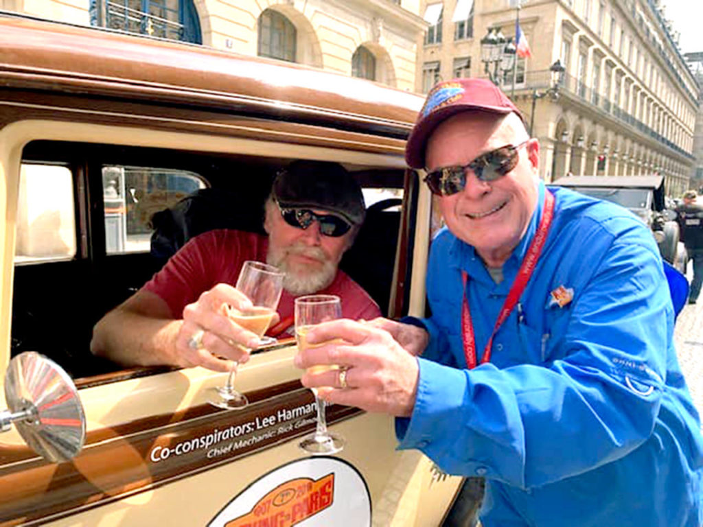 Bill Ward (left) and Lee Harmon share a celebratory champagne toast at the finish line of the 36-day Peking to Paris Motor Challenge.

