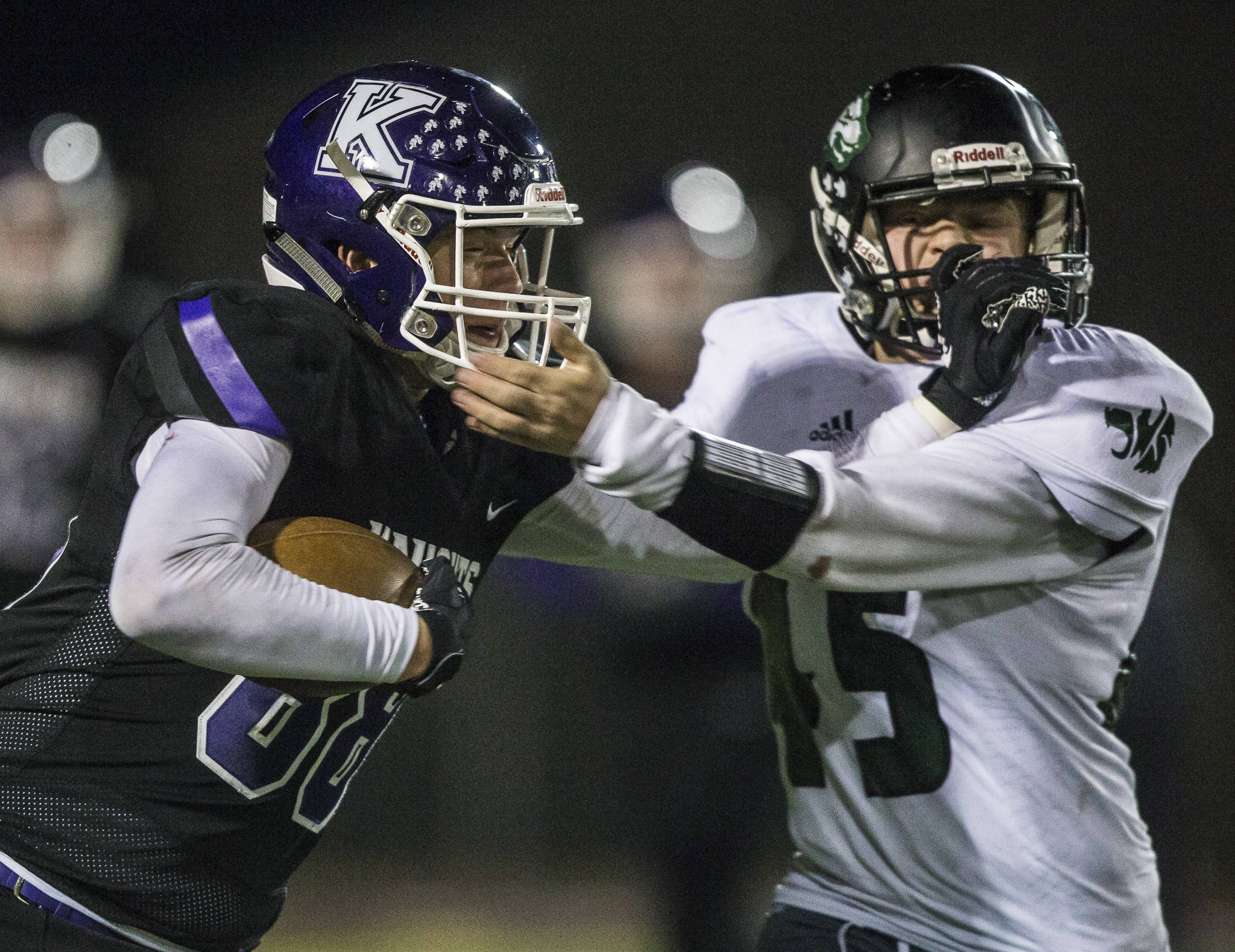 Kamiak’s Ben Farrara (left) and Jackson’s Jack Barclay grab each others facemasks during a game on Nov. 1 at Goddard Stadium in Everett. (Olivia Vanni / The Herald)