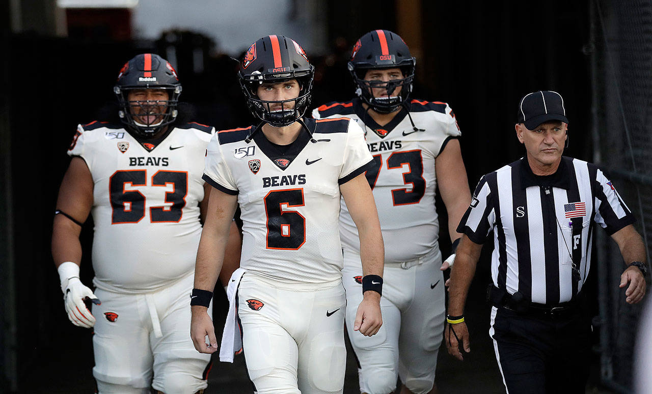 Oregon State quarterback Jake Luton (6) leads the Beavers onto the field at the Rose Bowl alongside teammates Gus Lavaka (left) and Blake Brandel before an Oct. 5 game against UCLA in Pasadena, California. (AP Photo/Marcio Jose Sanchez)
